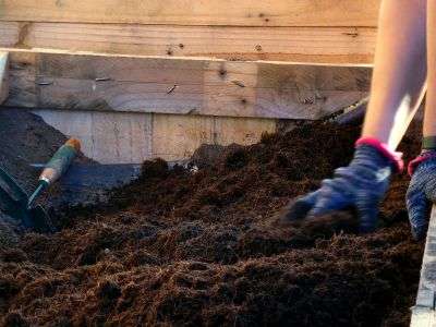Mixing compost to prepare soil for planting